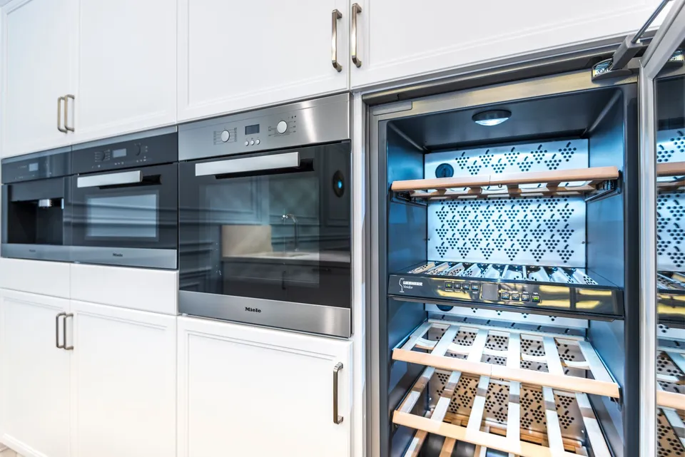 Vinoteca empotrada en el mueble de una cocina moderna, con las baldas iluminadas